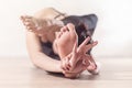 Woman doing yoga meditation and stretching exercises bending forward with her leg behind head. Royalty Free Stock Photo