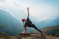 Woman doing yoga on mountain cliff at sunrise. Mountanious landscape Royalty Free Stock Photo
