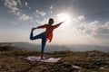 Woman doing yoga, Natarajasana asana - outdoor dance pose at sunset in the mountains. A yogi on a rug balances near a Royalty Free Stock Photo