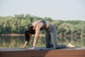 Woman doing yoga outdoors in a beautiful spot on a riverside