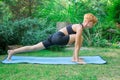 Woman doing yoga in the park, young girl doing various wellness exercises