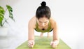 Woman doing yoga plank on the green yoga mat for meditite and excercise in the home Royalty Free Stock Photo