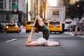 Woman doing yoga pose on city street of New York.