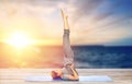 Woman doing yoga in shoulderstand pose on mat