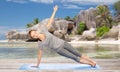 Woman doing yoga in side plank pose on beach Royalty Free Stock Photo