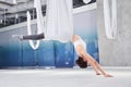 Woman doing yoga splits on fabric hangers