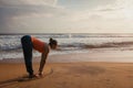 Woman doing yoga Sun salutation Surya Namaskar on beach