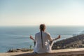 woman doing yoga in the top of a cliff in the mountain. Woman meditates in yoga asana Padmasana Royalty Free Stock Photo