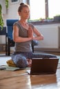 woman doing yoga workout at home watching videos online on laptop computer Royalty Free Stock Photo