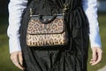 Woman with Dolce e Gabbana leopard skin bag and black dress before Giorgio Armani fashion show, Milan Fashion