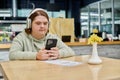 woman with down syndrome holding smartphone