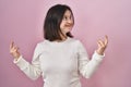 Woman with down syndrome standing over pink background showing middle finger doing fuck you bad expression, provocation and rude Royalty Free Stock Photo