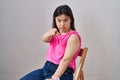 Woman with down syndrome wearing band aid for vaccine injection pointing with finger to the camera and to you, confident gesture Royalty Free Stock Photo