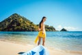 Woman dragging her boat to the water on the beach