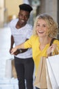 Woman dragging reluctant boyfriend shopping