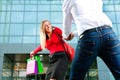 Woman dragging man into shopping mall Royalty Free Stock Photo