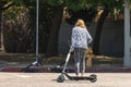 Woman drags BIRD scooter across the street