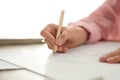 Woman drawing girl`s portrait with pencil on sheet of paper at table, closeup Royalty Free Stock Photo