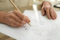 Woman drawing girl`s portrait with pencil on sheet of paper at table Royalty Free Stock Photo