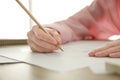 Woman drawing girl`s portrait with pencil on sheet of paper at wooden table Royalty Free Stock Photo