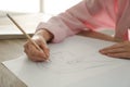 Woman drawing girl`s portrait with pencil on sheet of paper at wooden table, closeup Royalty Free Stock Photo