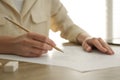 Woman drawing girl`s portrait with pencil on sheet of paper at wooden table, closeup Royalty Free Stock Photo