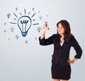 Woman drawing light bulb on whiteboard Royalty Free Stock Photo