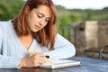 Woman drawing on notebook in a terrace Royalty Free Stock Photo