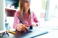 Woman drawing something on graphic tablet at the home office