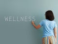 Woman drawing with white chalk on wall