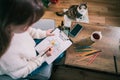 Woman drawing work-life balance wheel sitting on the sofa at home. Self-reflection and life planning for next new year