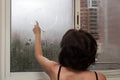 A woman draws a heart on a fogged window with her finger concept Royalty Free Stock Photo