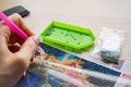 A woman draws a picture with beads. A set of images made of beads, handicrafts