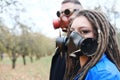 A woman with dreadlocks and a gas mask and a man with steampunk goggles and a gas mask pose in the autumn park Royalty Free Stock Photo