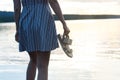 Woman in dress enjoying beautiful sunset on the beach.