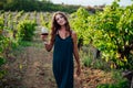 a woman in a dress with a glass of wine in a vineyard of nature