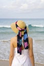 A woman with dress and hat on the beach