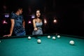 Woman in dress playing pool with a man in a pub Royalty Free Stock Photo