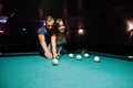 Woman in dress playing pool with a man in a pub Royalty Free Stock Photo