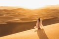 Woman in dress, sand dunes in desert, warm evening light, beautiful pastel tone Royalty Free Stock Photo
