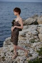 woman in dress standing on stones posing in beach dress luxury unaltered