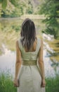 Woman in dress stay beside a lake