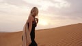 Woman in dress with view of desert sand in sunset light. Landscape Royalty Free Stock Photo