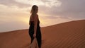 Woman in dress with view of desert sand in sunset light. Landscape Royalty Free Stock Photo