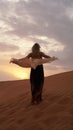 Woman in dress with view of desert sand in sunset light. Landscape Royalty Free Stock Photo