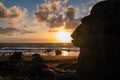 Woman in dress walking barefoot on volcanic sand beach Playa del Ingles during sunset in Valle Gran Rey on La Gomera,