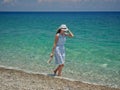 Woman in dress walking by the sea Royalty Free Stock Photo