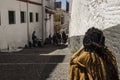 Woman dressed in arabic clothes and dreadlocks in her hair is sitting smoking on a nice street in the famous Albaicin neighborhood