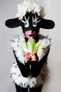 Woman dressed as sheep. Girl eating cabbage.