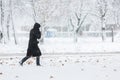 Woman dressed in black coat walking alone